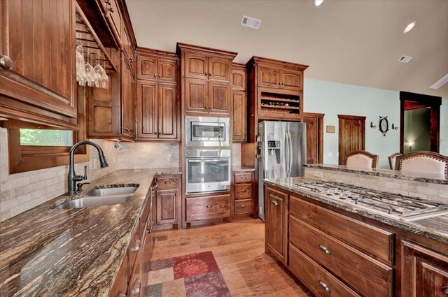 2801 John Deere Ave Unit 1, Edmond, OK 73034 - kitchen with appliances with stainless steel finishes, a sink, tasteful backsplash, dark stone countertops, and lofted ceiling