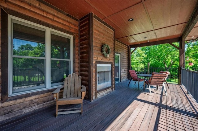 2801 John Deere Ave Unit 1, Edmond, OK 73034 - wooden deck with outdoor dining space and an outdoor fireplace