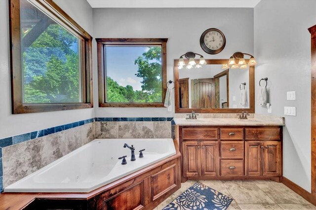 2801 John Deere Ave Unit 1, Edmond, OK 73034 - bathroom with double vanity, a tub with jets, and tile patterned flooring