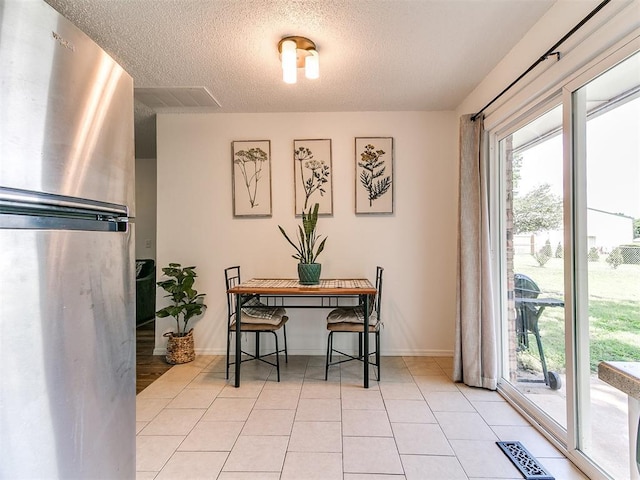808 Robin Hill Rd, Edmond, OK 73003 - dining area featuring a textured ceiling, light tile patterned floors, and baseboards