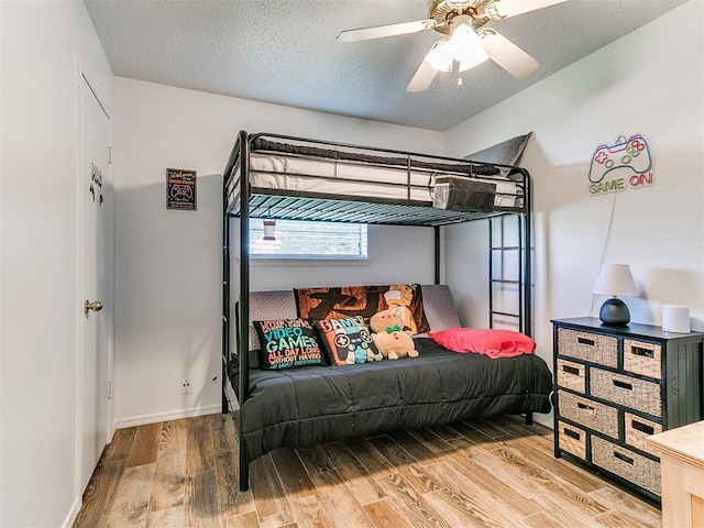 808 Robin Hill Rd, Edmond, OK 73003 - bedroom featuring wood finished floors, baseboards, a textured ceiling, and a ceiling fan
