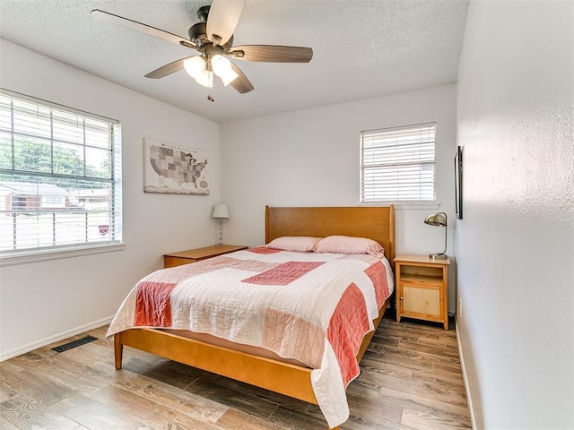 808 Robin Hill Rd, Edmond, OK 73003 - bedroom featuring wood finished floors, baseboards, ceiling fan, and a textured ceiling
