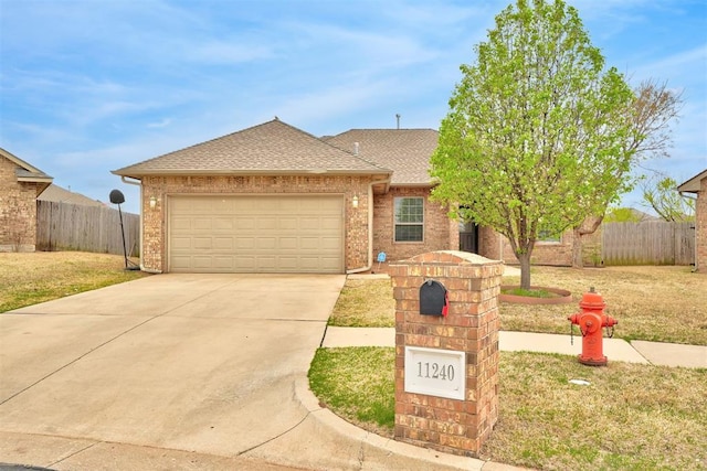 11240 NW 106th St, Yukon, OK 73099 - view of front of home with an attached garage, driveway, roof with shingles, and brick siding