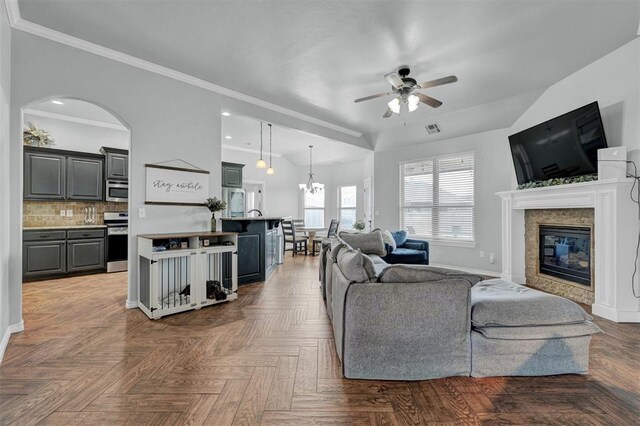 11240 NW 106th St, Yukon, OK 73099 - living room with ceiling fan, a glass covered fireplace, baseboards, ornamental molding, and a chandelier