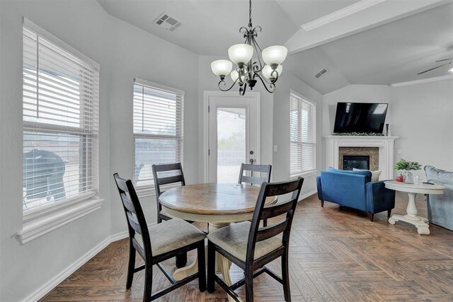 11240 NW 106th St, Yukon, OK 73099 - dining area featuring vaulted ceiling, healthy amount of natural light, a glass covered fireplace, baseboards, and a chandelier