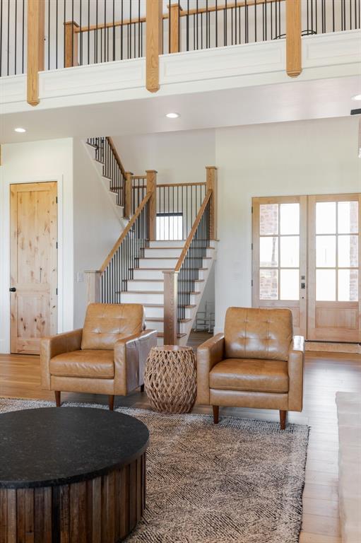 16000 N Hogback Rd, Luther, OK 73054 - living room featuring a towering ceiling, wood finished floors, stairway, and french doors
