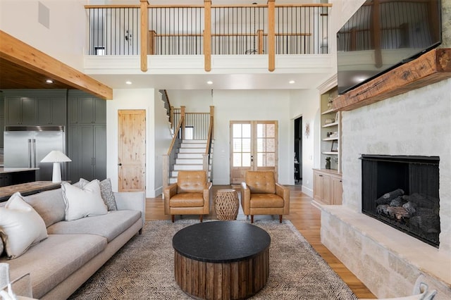 16000 N Hogback Rd, Luther, OK 73054 - living room featuring a high ceiling, light wood-style floors, stairway, built in shelves, and a fireplace with raised hearth