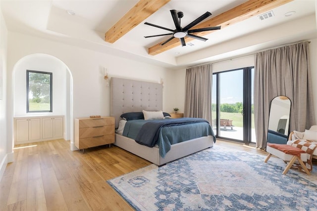 16000 N Hogback Rd, Luther, OK 73054 - bedroom featuring access to outside, light wood-style floors, multiple windows, beamed ceiling, and arched walkways