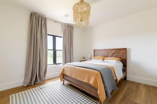 16000 N Hogback Rd, Luther, OK 73054 - bedroom featuring a chandelier, wood finished floors, and baseboards