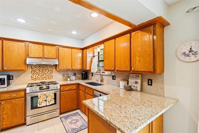 2016 Castle Rock, Edmond, OK 73003 - kitchen featuring stainless steel appliances, under cabinet range hood, a sink, a textured ceiling, and decorative backsplash