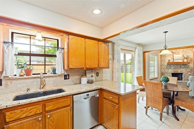 2016 Castle Rock, Edmond, OK 73003 - kitchen featuring dishwasher, a sink, a textured ceiling, a peninsula, and light stone counters