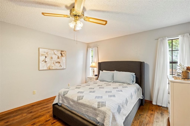2016 Castle Rock, Edmond, OK 73003 - bedroom featuring wood finished floors, a textured ceiling, a ceiling fan, and baseboards