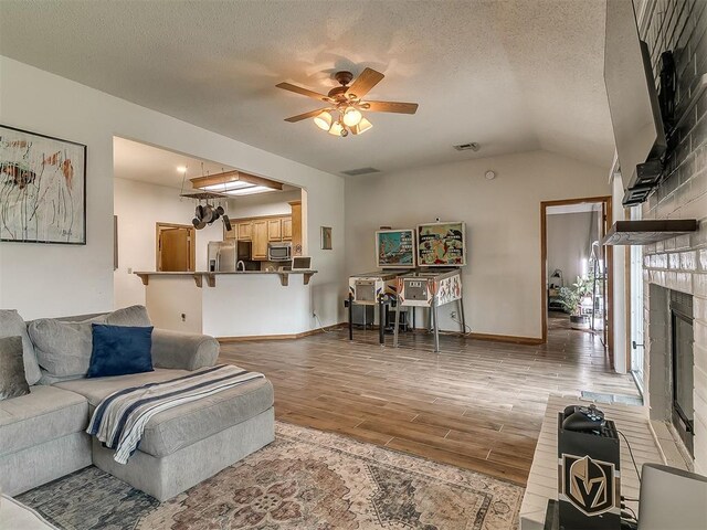 1813 Richard Dr, Edmond, OK 73003 - living room with light wood finished floors, a fireplace, ceiling fan, lofted ceiling, and baseboards