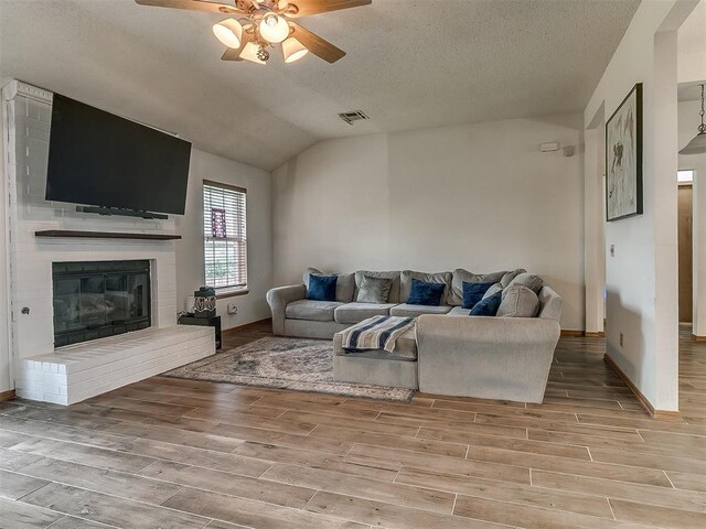 1813 Richard Dr, Edmond, OK 73003 - living room featuring ceiling fan, light wood-style floors, a brick fireplace, lofted ceiling, and baseboards
