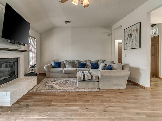 1813 Richard Dr, Edmond, OK 73003 - living room featuring light wood-type flooring, ceiling fan, a fireplace, vaulted ceiling, and baseboards