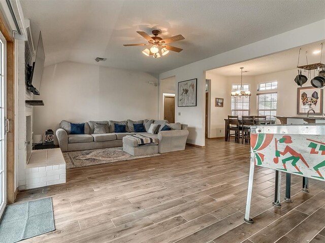 1813 Richard Dr, Edmond, OK 73003 - living area with wood finished floors, a ceiling fan, a chandelier, and lofted ceiling