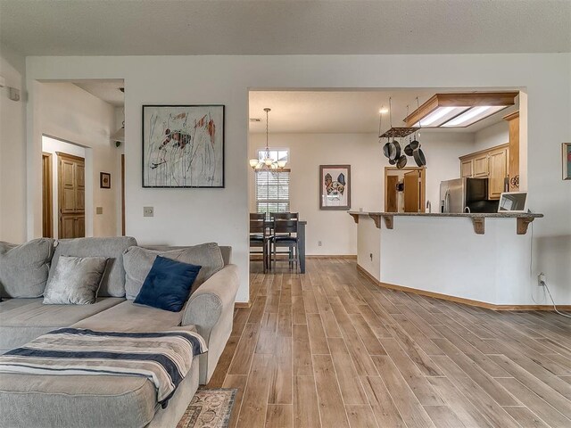 1813 Richard Dr, Edmond, OK 73003 - living area with light wood-style floors, a chandelier, and baseboards