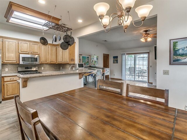 1813 Richard Dr, Edmond, OK 73003 - kitchen with appliances with stainless steel finishes, tasteful backsplash, vaulted ceiling, light brown cabinetry, and ceiling fan