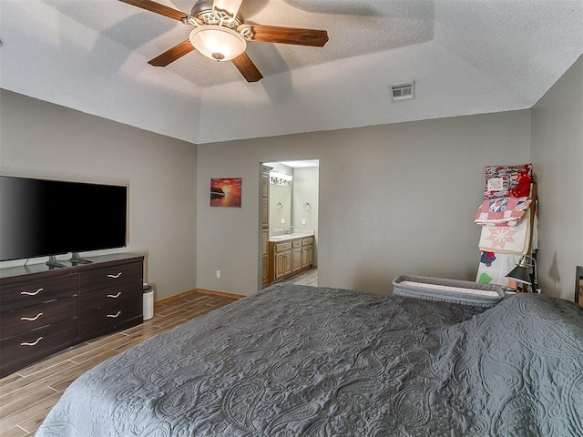 1813 Richard Dr, Edmond, OK 73003 - bedroom with wood tiled floors, lofted ceiling, ceiling fan, a textured ceiling, and connected bathroom