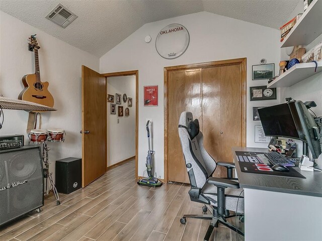 1813 Richard Dr, Edmond, OK 73003 - office with lofted ceiling, light wood-type flooring, baseboards, and a textured ceiling