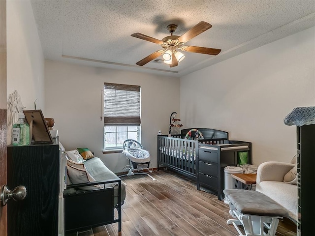 1813 Richard Dr, Edmond, OK 73003 - bedroom with a textured ceiling, wood finished floors, and ceiling fan