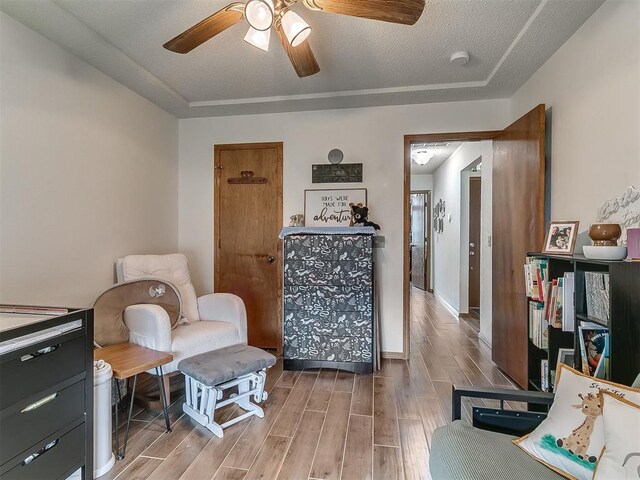 1813 Richard Dr, Edmond, OK 73003 - sitting room featuring light wood-style floors, a ceiling fan, a textured ceiling, and baseboards