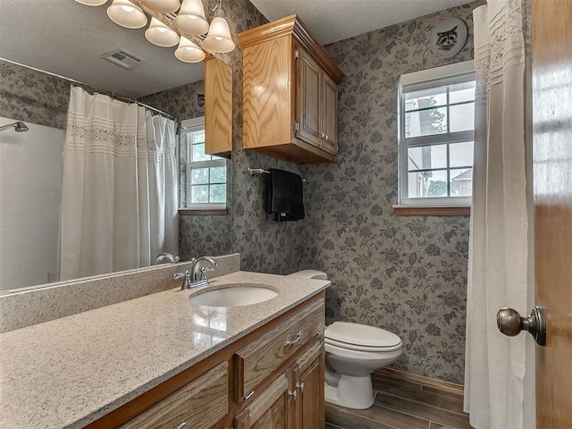 1813 Richard Dr, Edmond, OK 73003 - full bath with wood finished floors, vanity, toilet, wallpapered walls, and baseboards