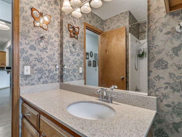 1813 Richard Dr, Edmond, OK 73003 - bathroom with wallpapered walls, vanity, a shower, and a chandelier