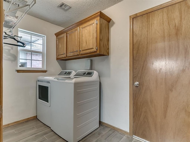 1813 Richard Dr, Edmond, OK 73003 - laundry area with washer and dryer, cabinet space, light wood finished floors, baseboards, and a textured ceiling