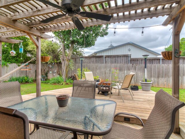 1813 Richard Dr, Edmond, OK 73003 - fenced backyard featuring a wooden deck, outdoor dining area, ceiling fan, a pergola, and an outdoor fire pit