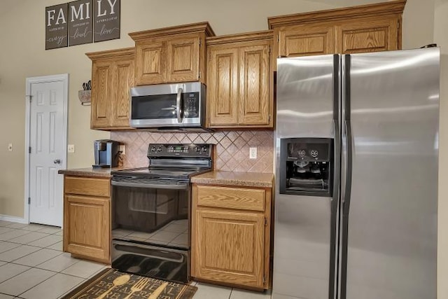 3224 Peacock Ln, Altus, OK 73521 - kitchen featuring stainless steel appliances, backsplash, light tile patterned flooring, brown cabinets, and baseboards