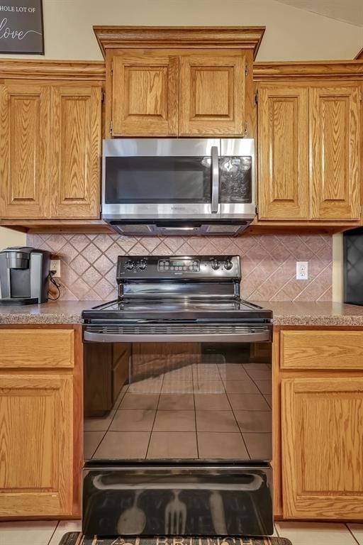 3224 Peacock Ln, Altus, OK 73521 - kitchen with stainless steel microwave, black electric range, tasteful backsplash, and tile patterned floors