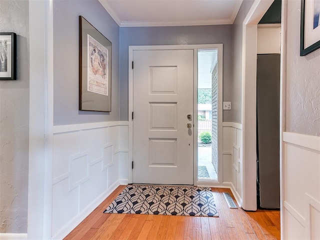 203 N Sherry Ave, Norman, OK 73069 - foyer entrance featuring light wood finished floors, a decorative wall, wainscoting, and crown molding