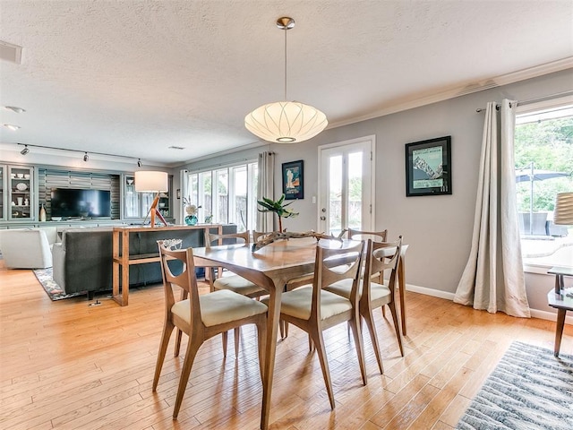 203 N Sherry Ave, Norman, OK 73069 - dining room with a textured ceiling, light wood-type flooring, plenty of natural light, ornamental molding, and baseboards