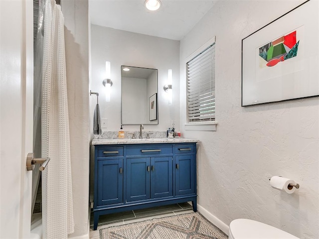 203 N Sherry Ave, Norman, OK 73069 - bathroom with toilet, vanity, a shower with shower curtain, a textured wall, and baseboards