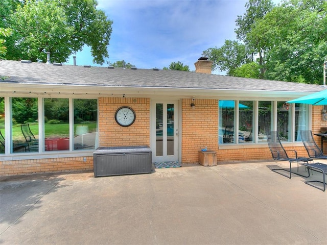 203 N Sherry Ave, Norman, OK 73069 - view of front of house with a patio area, brick siding, a chimney, and a shingled roof