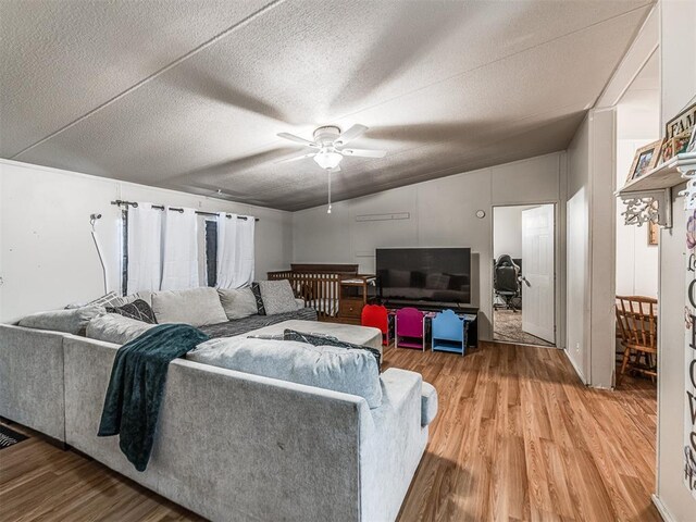 14417 Longhorn Dr, Jones, OK 73049 - living area with light wood-type flooring, vaulted ceiling, ceiling fan, and a textured ceiling