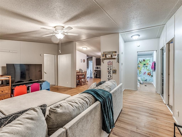 14417 Longhorn Dr, Jones, OK 73049 - living room with light wood-type flooring, ceiling fan, attic access, and a textured ceiling