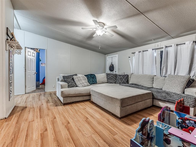 14417 Longhorn Dr, Jones, OK 73049 - living room with ceiling fan, light wood finished floors, lofted ceiling, and a textured ceiling