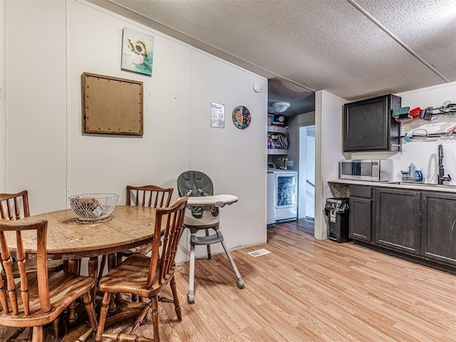 14417 Longhorn Dr, Jones, OK 73049 - dining area with washer / clothes dryer, light wood finished floors, and a textured ceiling
