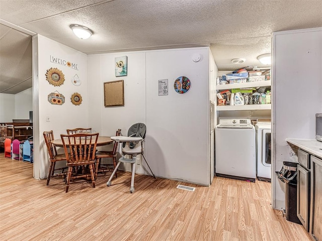 14417 Longhorn Dr, Jones, OK 73049 - dining room with washing machine and dryer, light wood-style floors, and a textured ceiling