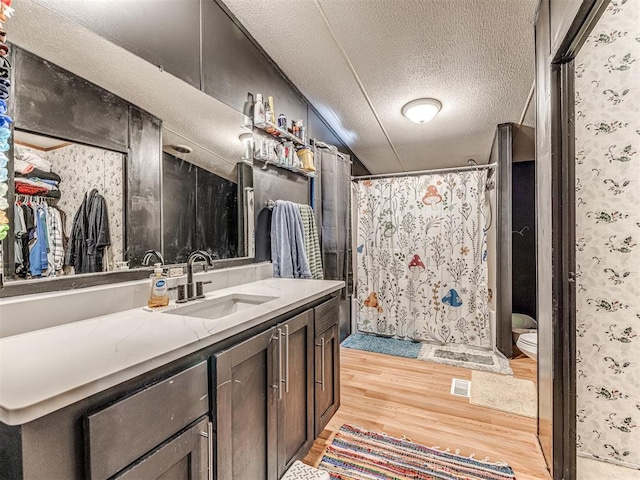 14417 Longhorn Dr, Jones, OK 73049 - bathroom featuring wood finished floors, vanity, toilet, a textured ceiling, and a shower with curtain
