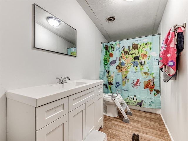 14417 Longhorn Dr, Jones, OK 73049 - bathroom featuring toilet, vanity, wood finished floors, curtained shower, and a textured ceiling