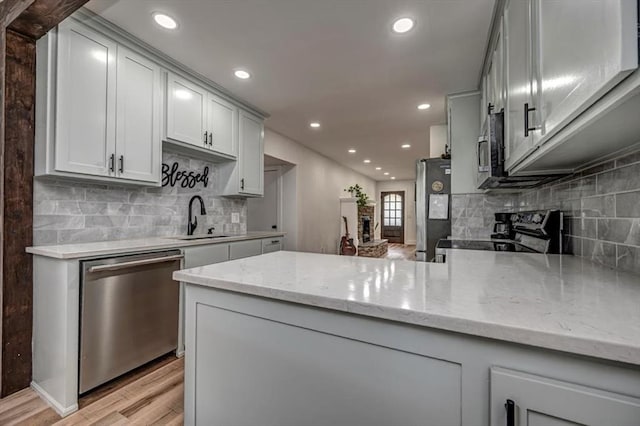 2401 Davis Rd, Guthrie, OK 73044 - kitchen featuring stainless steel appliances, a sink, light wood-style flooring, tasteful backsplash, and recessed lighting