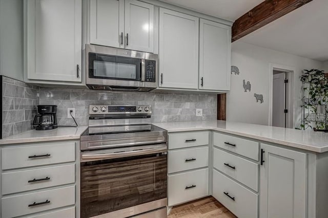 2401 Davis Rd, Guthrie, OK 73044 - kitchen with stainless steel appliances, a peninsula, decorative backsplash, beam ceiling, and white cabinets