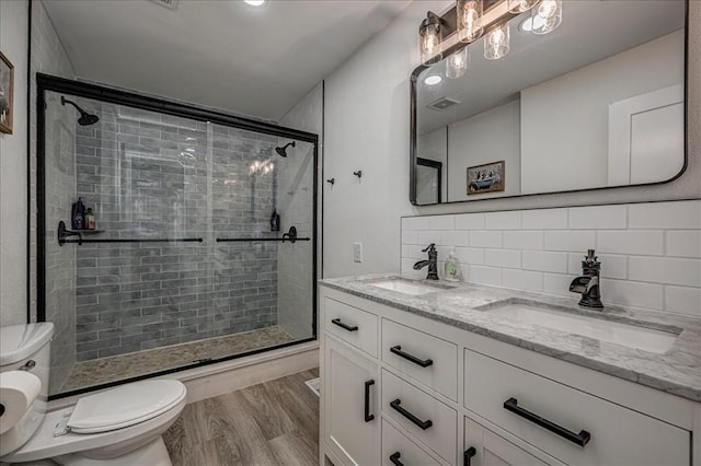 2401 Davis Rd, Guthrie, OK 73044 - full bath featuring toilet, double vanity, tiled shower, tasteful backsplash, and wood finished floors