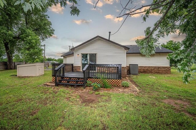 2401 Davis Rd, Guthrie, OK 73044 - back of house at dusk with a deck, a yard, and central AC