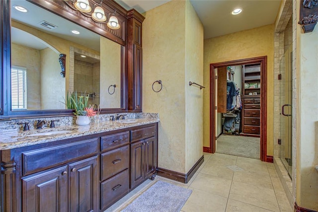 14220 SE 76th Pl, Oklahoma City, OK 73150 - bathroom with double vanity, a stall shower, a walk in closet, tile patterned flooring, and recessed lighting