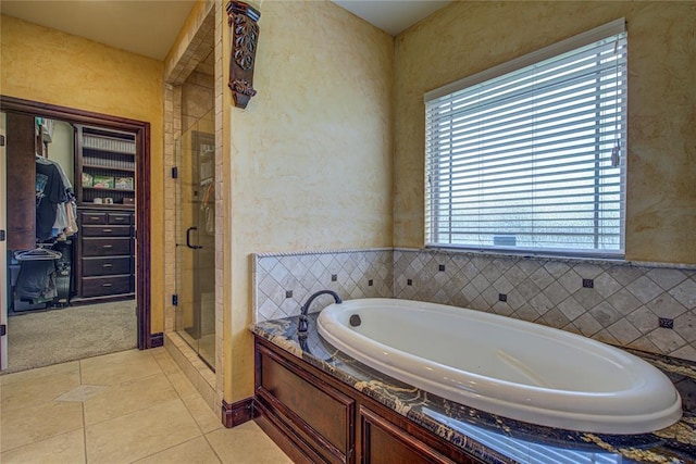 14220 SE 76th Pl, Oklahoma City, OK 73150 - bathroom featuring a garden tub, a shower stall, a textured wall, and tile patterned flooring