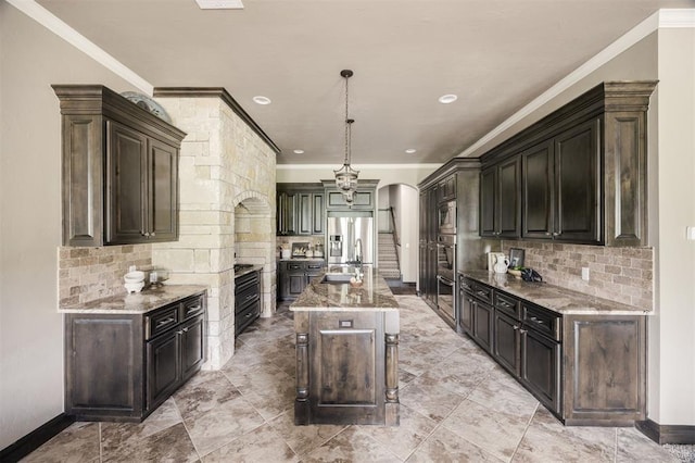 15101 Colonia Bella Dr, Edmond, OK 73013 - kitchen featuring ornamental molding, light stone counters, arched walkways, backsplash, and recessed lighting